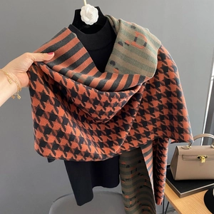 Detail of cashmere scarf showing orange houndstooth pattern and letter D stitching