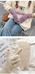 Detail of knitted gloves with touchscreen openings and branded label for winter warmth