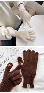 Close-up of knit gloves with finger openings for touchscreen use and woven wrist label