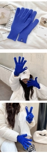 Detail of Klein blue knitted gloves showing fingertip openings and rib-knit texture
