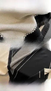 Detail view of the hand-woven tassels and geometric patterns on a soft winter scarf