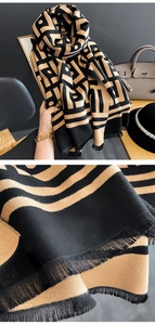 Dettaglio ravvicinato di sciarpa jacquard geometrica nera e gialla con nappe a frange