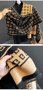 Close-up of thick knit fabric with geometric letter pattern and tassel fringe detail