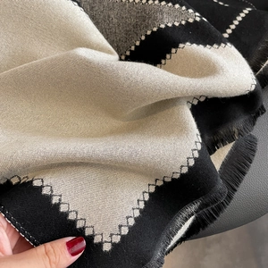 Minimalist beige and black color-block knit scarf with elegant fringe detail