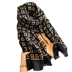 Reversible knit scarf with classic letter jacquard pattern and fringe trim in brown and black