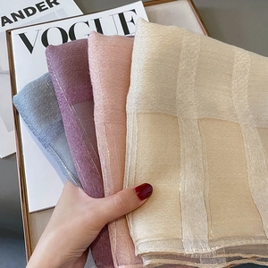 Detailed view of four shimmering silk-blend scarves with plaid texture and gold metallic threads