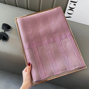 Detail of pink silk blend scarf with elegant gold metallic stripes on fashion tray