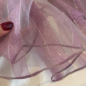 Detail of purple silk blend scarf fabric with delicate gold metallic stripes and texture