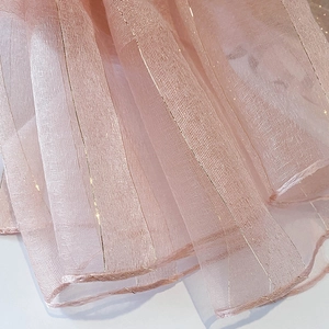 Detail of pink silk blend scarf featuring vertical gold metallic stripes and fine stitching