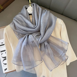 Detailed view of light gray silk blend scarf with metallic thread and diamond weave texture