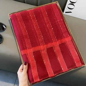 Detail of red silk blend scarf with vertical stripes and fine golden glitter threads