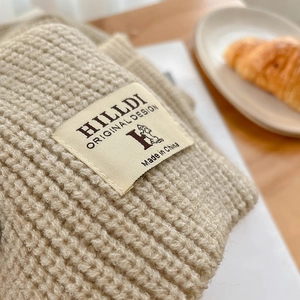Gros plan sur maille épaisse crème avec étiquette de marque sur table de petit-déjeuner