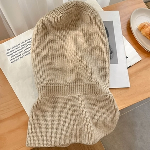 Gros plan sur la texture en maille côtelée épaisse d'une cagoule beige aux détails d'hiver