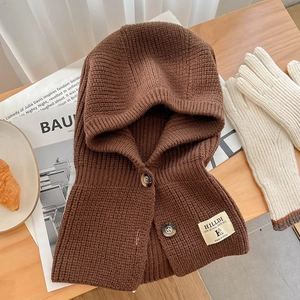 Vue détaillée de la cagoule en maille marron foncé avec texture épaisse et boutons en ambre