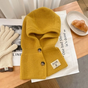 Détail de la cagoule en grosse maille jaune avec boutons et gants assortis chauds