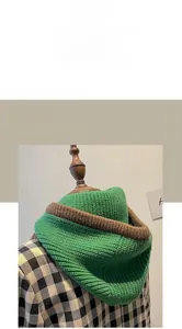 Detail der Strickhaube mit Schal in Grün und Braun mit dekorativem Knopfverschluss