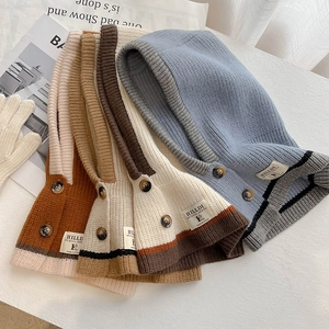 Detailaufnahme dicker Strick-Sturmhauben mit Vintage-Knöpfen in verschiedenen Farben