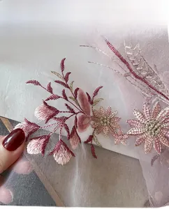 Detail of pink silk blend scarf featuring exquisite purple floral embroidery and neat edges