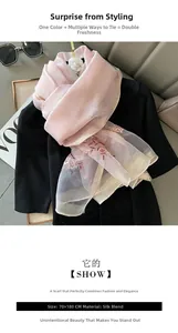 Close-up of pink silk blend scarf with detailed floral embroidery and gold trim