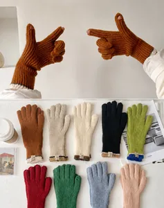 Detalle de guantes de punto táctiles con aberturas para dedos y opciones de colores