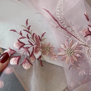 Detailed embroidery on sheer silk blend scarf showing floral patterns and gold thread