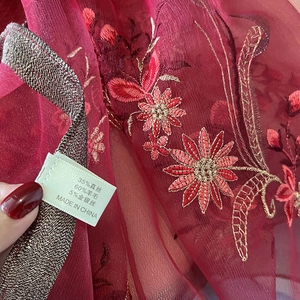 Close-up of embroidered silk wool blend scarf fabric with metallic floral patterns