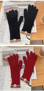 Dettaglio di guanti touch in maglia con trama a coste ed etichette cucite a contrasto