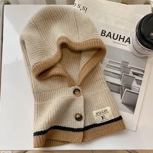 Nahaufnahme der beige Strick-Sturmhaube mit braunem Rand und Holzknopf-Details