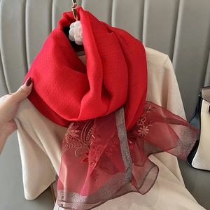 Detail of red silk blend scarf featuring floral embroidery and organza trim edges