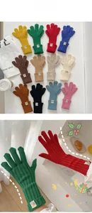 Close-up of ribbed knit texture and woven label on colorful winter touchscreen gloves