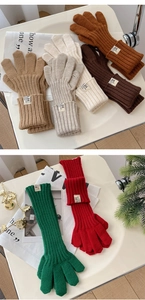 Detail of knitted winter gloves featuring long ribbed cuffs and colorful wool textures