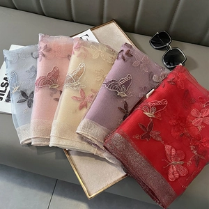 Détail de cinq écharpes en soie et laine avec broderie florale et bordure brillante
