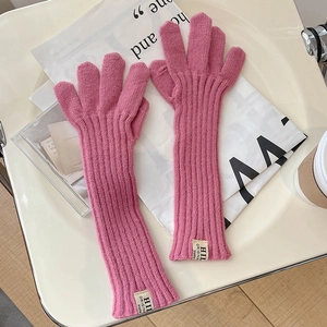 Detail of rose pink knitted gloves with vertical stripe pattern and woven label