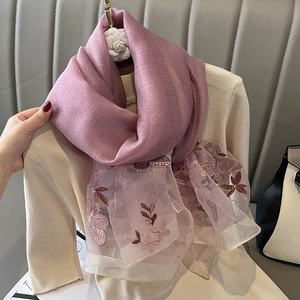 Détail de broderies florales roses et bordure en dentelle sur châle en laine et soie