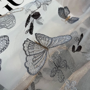 Vue macro détaillée d'une broderie papillon délicate sur un châle en soie et laine