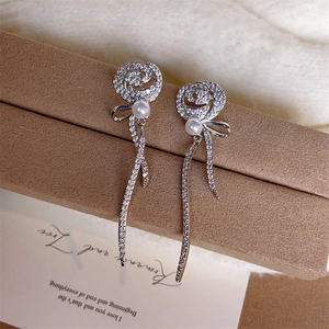 Boucles d'oreilles roses élégantes avec perles blanches et longs glands en zircon sur boîte