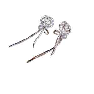 Boucles d'oreilles rose élégantes avec zircon brillant, perle et détails de pompon ruban