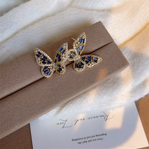 Gold butterfly stud earrings with blue baguette crystals and micro-pave zircons