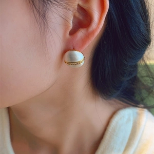 Luxurious geometric dual-tone stud earrings with matte white finish and micro-paved diamonds