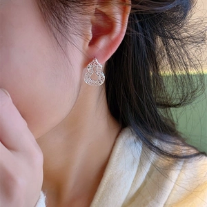 Boucles d'oreilles gourde en filigrane d'argent portées par un mannequin de profil