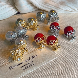 Detailed macro of vintage pearl stud earrings with crown setting and zircon inlay