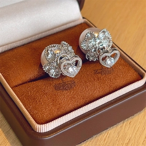 Detailed view of silver heart pearl earrings with sparkling zircon inlay in a jewelry box
