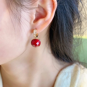 Elegant red faceted gemstone heart earrings with gold hooks and zircon inlay on model