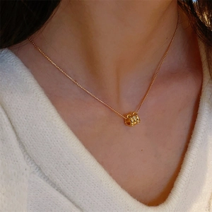 Elegant gold pendant necklace with crystal multi-ring design worn on female neck