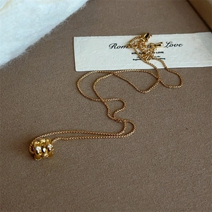 Macro detail of gold-plated cylinder necklace with cubic zirconia rings on velvet