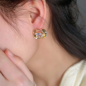 Elegant gold wavy hoop earrings with rectangular crystal on female model