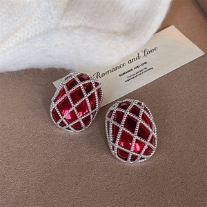 Close-up of red French retro earrings with silver geometric mesh pattern detail