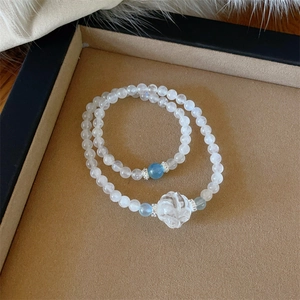 Double-layered white moonstone and blue crystal beaded bracelet with a floral charm