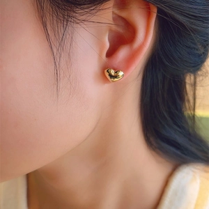 Elegant 3D gold heart stud earrings on model for a minimalist aesthetic look