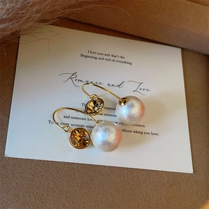 Elegant champagne crystal and white pearl drop earrings on a romantic gift card display